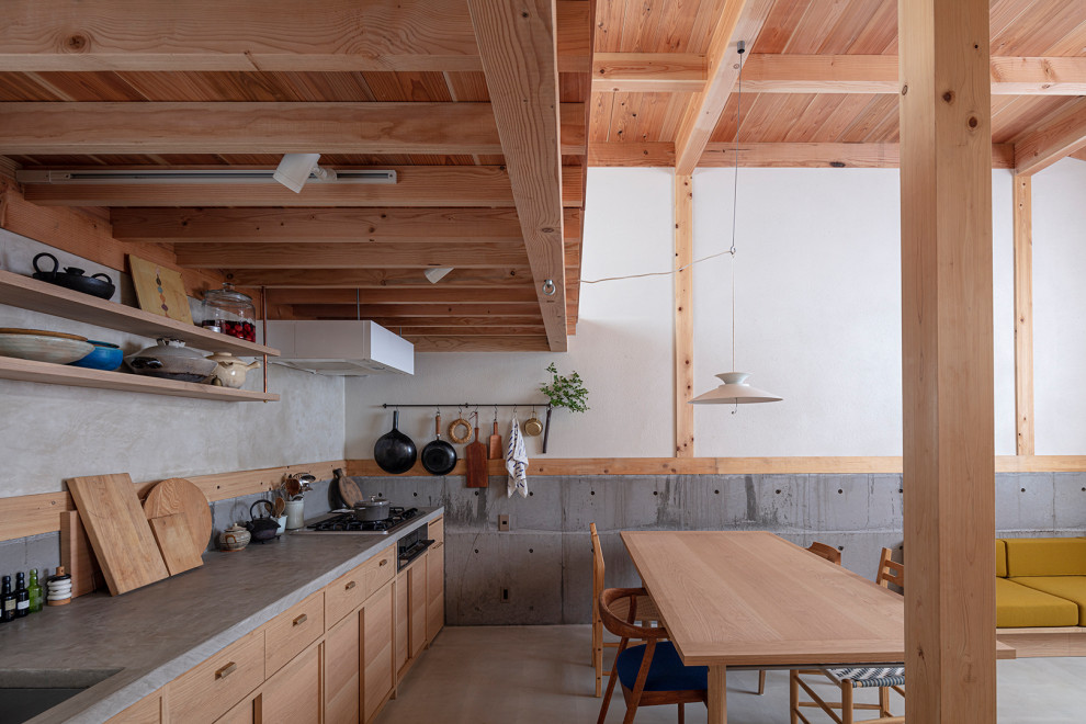 Inredning av ett nordiskt litet grå linjärt grått kök med öppen planlösning, med en undermonterad diskho, bänkskiva i betong, betonggolv och grått golv