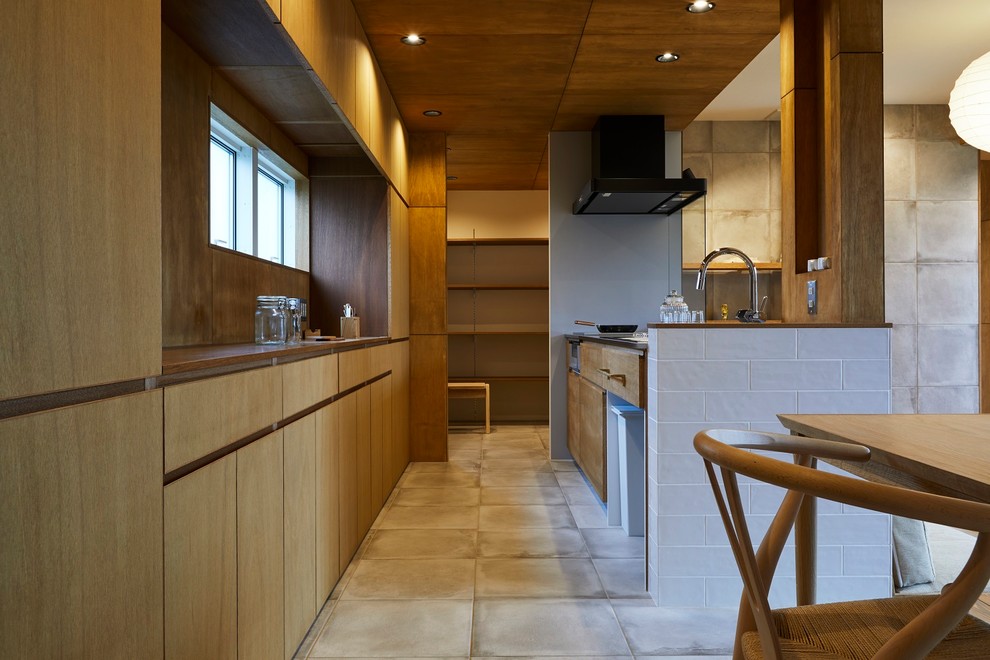 Inspiration för ett mellanstort funkis brun linjärt brunt kök med öppen planlösning, med en integrerad diskho, släta luckor, bruna skåp, bänkskiva i rostfritt stål, stänkskydd med metallisk yta, rostfria vitvaror, klinkergolv i porslin och grått golv
