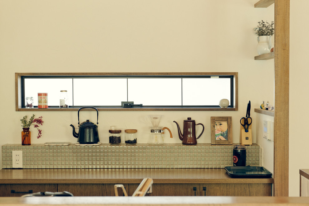 名古屋にあるカントリー風のおしゃれなキッチン (フラットパネル扉のキャビネット、中間色木目調キャビネット、木材カウンター、グレーのキッチンパネル、モザイクタイルのキッチンパネル) の写真