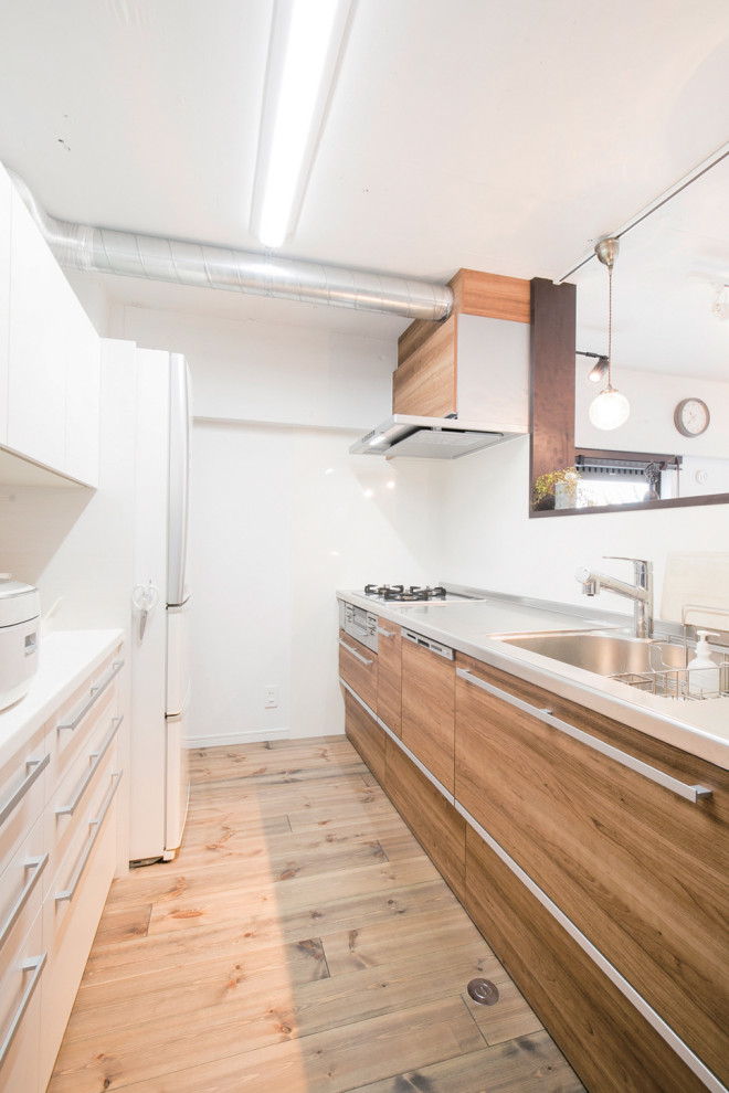 Enclosed kitchen - industrial single-wall dark wood floor and wallpaper ceiling enclosed kitchen idea in Fukuoka with an integrated sink, flat-panel cabinets, stainless steel countertops, white backsplash and stainless steel appliances