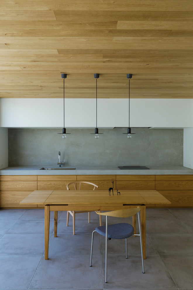 Bild på ett funkis grå linjärt grått kök och matrum, med en undermonterad diskho, släta luckor, skåp i mellenmörkt trä, bänkskiva i betong, grått stänkskydd, integrerade vitvaror, betonggolv och grått golv