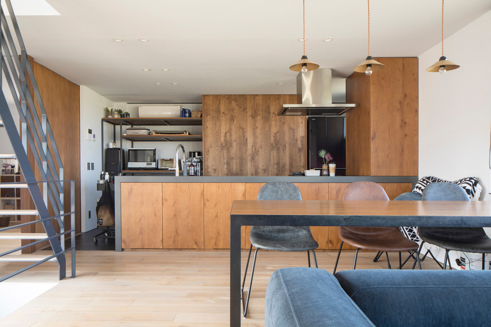札幌にあるコンテンポラリースタイルのおしゃれなキッチン (フラットパネル扉のキャビネット、中間色木目調キャビネット、黒い調理設備、淡色無垢フローリング、ベージュの床、グレーのキッチンカウンター) の写真