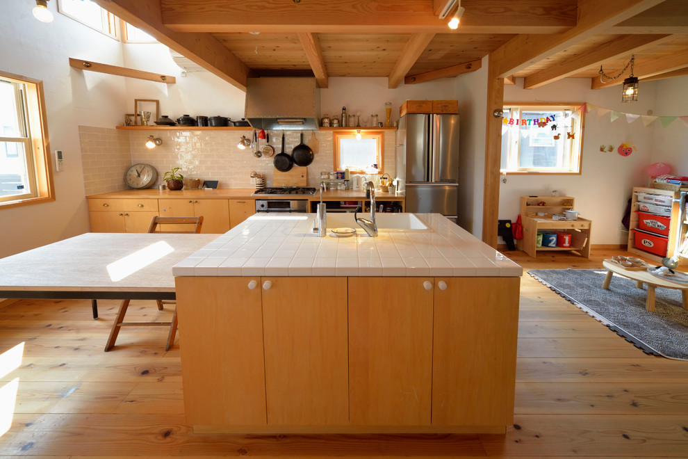 Exemple d'une cuisine ouverte tendance en bois brun avec un évier intégré, un placard à porte plane, un plan de travail en bois, une crédence blanche, un sol en bois brun, îlot et un sol marron.