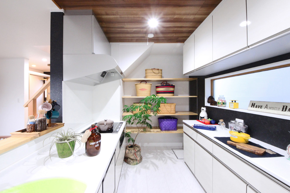 他の地域にあるインダストリアルスタイルのおしゃれなキッチン (フラットパネル扉のキャビネット、白いキャビネット、白いキッチンパネル、白い床) の写真