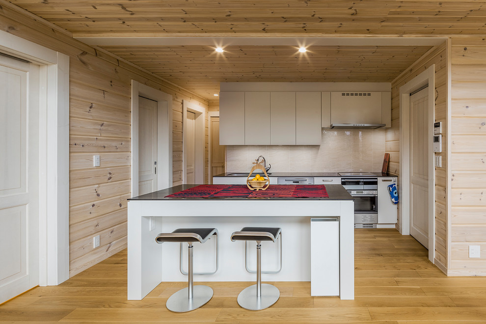 他の地域にある北欧スタイルのおしゃれなキッチン (シングルシンク、フラットパネル扉のキャビネット、白いキャビネット、ベージュキッチンパネル、無垢フローリング、茶色い床) の写真
