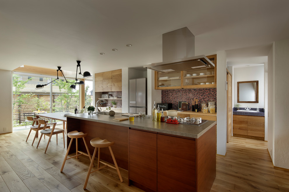 Exemple d'une cuisine ouverte linéaire nature en bois brun avec un évier 1 bac, un placard à porte plane, un sol en bois brun, îlot et un sol marron.