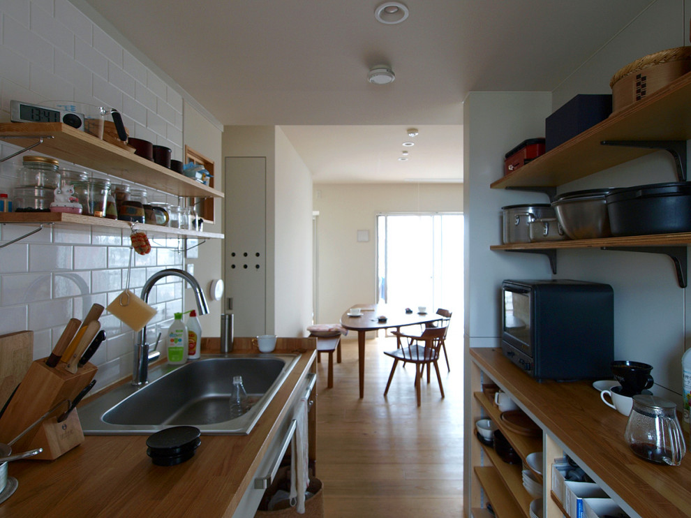 Photo of a retro single-wall enclosed kitchen in Tokyo with wood worktops, medium hardwood flooring and brown floors.