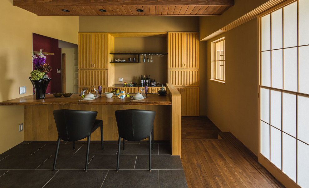 Cette photo montre une cuisine ouverte parallèle asiatique en bois brun avec un placard à porte persienne, parquet foncé, une péninsule et un sol marron.