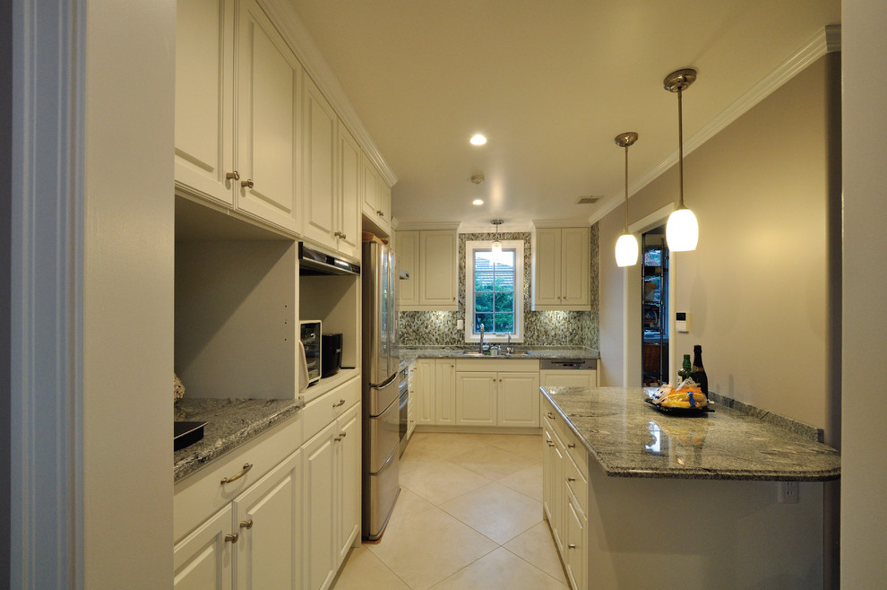 Exemple d'une cuisine victorienne fermée avec un placard avec porte à panneau surélevé, des portes de placard blanches, plan de travail en marbre, une crédence grise, une crédence en marbre, tomettes au sol et un sol beige.