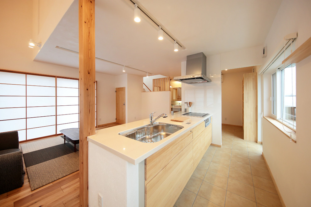 Cette image montre une cuisine ouverte linéaire asiatique en bois clair avec un évier 1 bac, un placard à porte affleurante, un plan de travail en surface solide, aucun îlot, un sol beige et un plan de travail blanc.