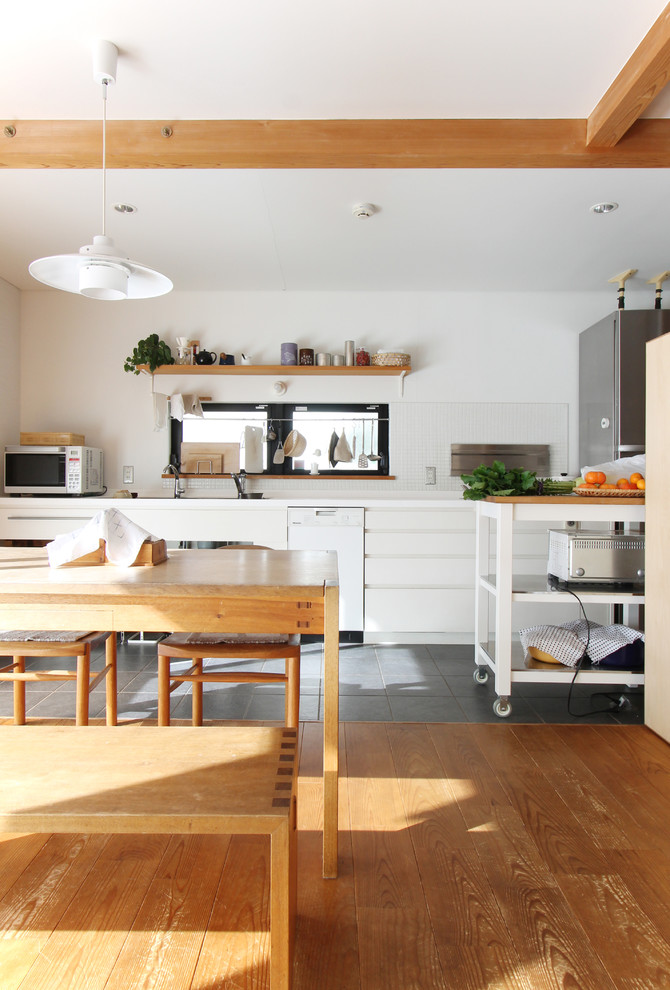 Example of a single-wall medium tone wood floor and brown floor eat-in kitchen design in Tokyo Suburbs with an undermount sink, flat-panel cabinets, white cabinets, white backsplash, stainless steel appliances and white countertops
