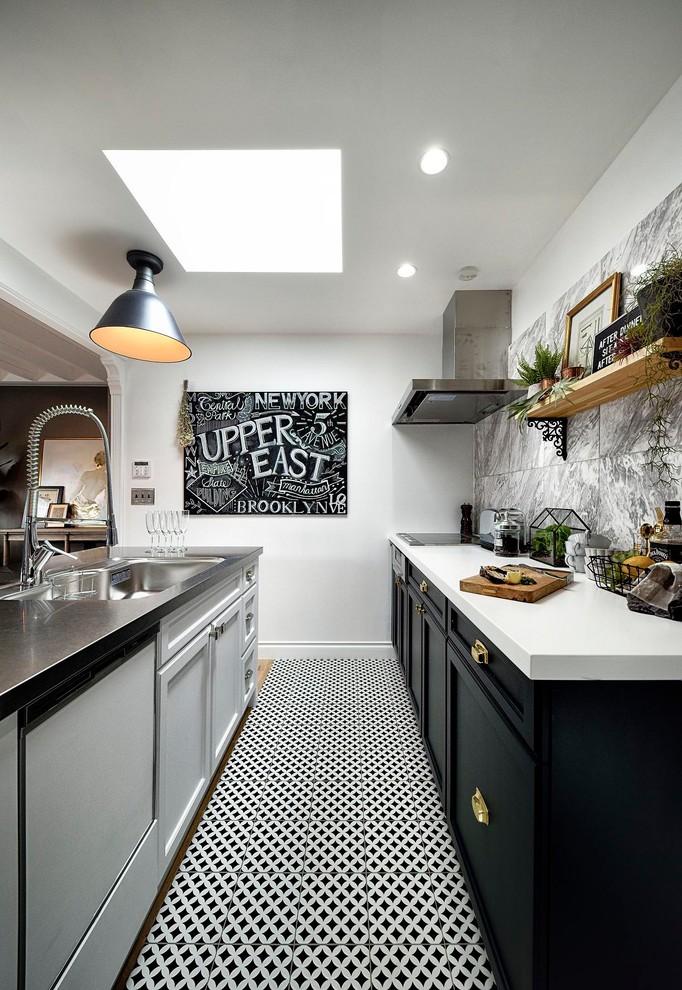 Modern inredning av ett kök, med en enkel diskho, luckor med infälld panel, vita skåp, bänkskiva i rostfritt stål och flerfärgat golv