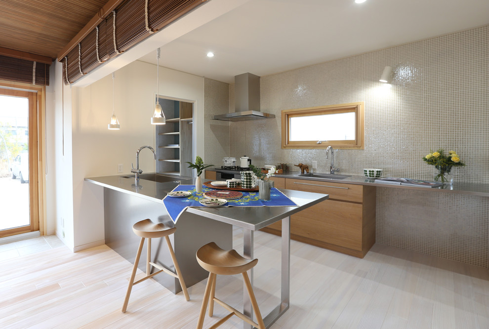 Contemporary galley kitchen in Other with flat-panel cabinets, light wood cabinets, mosaic tiled splashback, stainless steel appliances, light hardwood flooring and a breakfast bar.