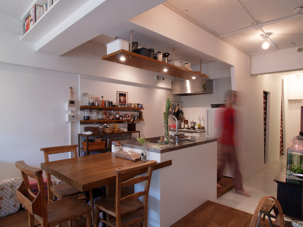 東京23区にある小さなインダストリアルスタイルのおしゃれなキッチン (一体型シンク、オープンシェルフ、中間色木目調キャビネット、ステンレスカウンター、白いキッチンパネル、ガラスタイルのキッチンパネル、白い調理設備、無垢フローリング) の写真