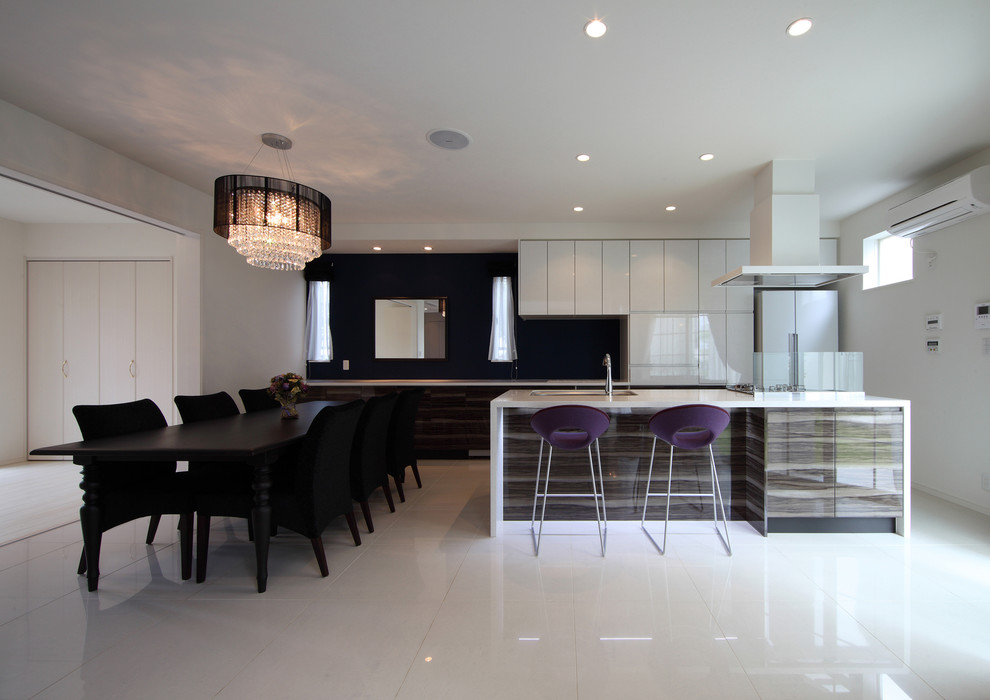 Пример оригинального дизайна: параллельная кухня-гостиная среднего размера в современном стиле с врезной мойкой, плоскими фасадами, черным фартуком, белой техникой, островом и белым полом