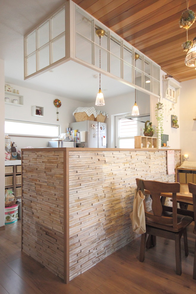 Idee per una cucina stile shabby con pavimento in legno massello medio e penisola