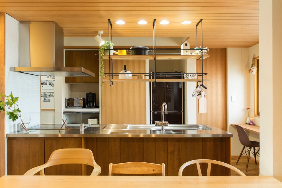 Idéer för ett stort industriellt brun linjärt kök med öppen planlösning, med bänkskiva i rostfritt stål, vitt stänkskydd, stänkskydd i stickkakel, mellanmörkt trägolv, brunt golv och en enkel diskho