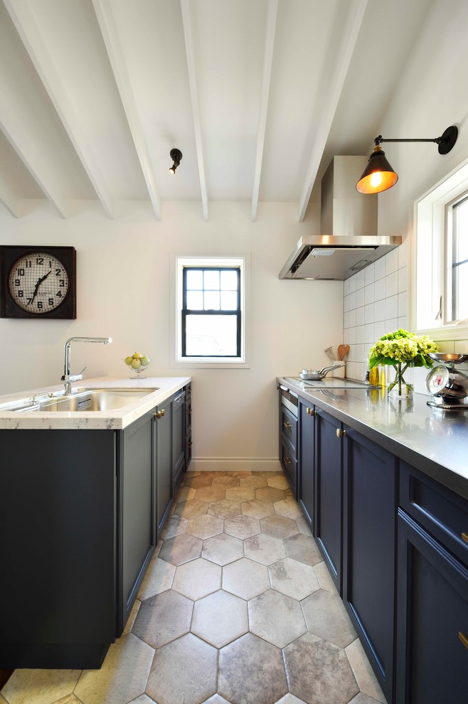 Idee per una cucina tradizionale con lavello a vasca singola, ante con riquadro incassato, ante nere, top in marmo, paraspruzzi bianco e pavimento grigio