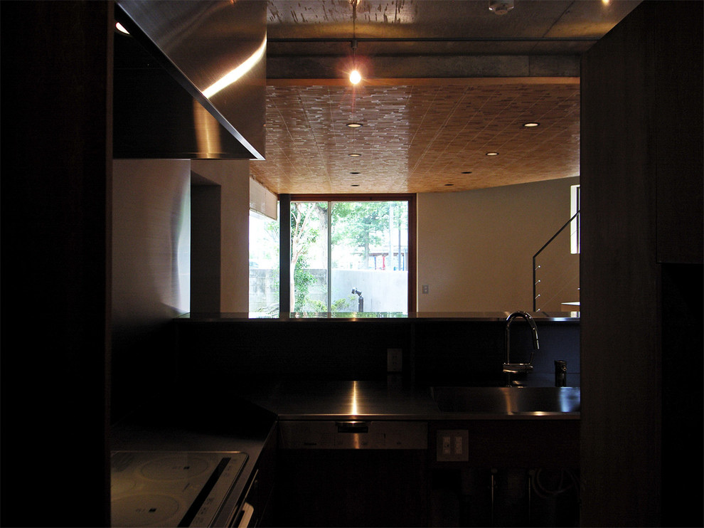 Esempio di una cucina a L moderna con lavello integrato, top in acciaio inossidabile, paraspruzzi grigio, elettrodomestici colorati e pavimento in legno massello medio