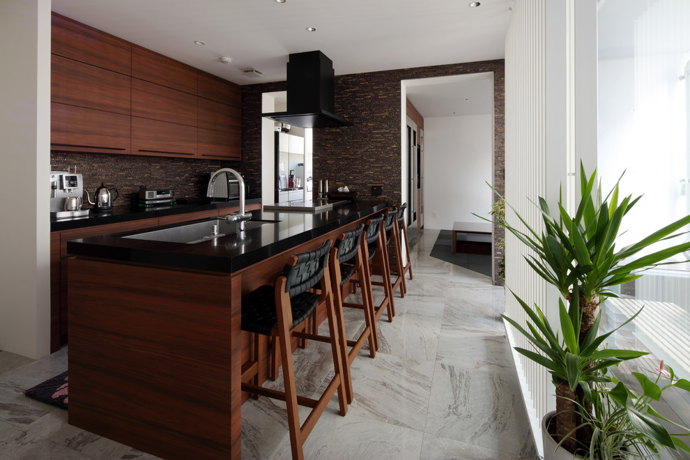 Стильный дизайн: кухня в восточном стиле с одинарной мойкой, плоскими фасадами, фасадами цвета дерева среднего тона, полуостровом и серым полом - последний тренд