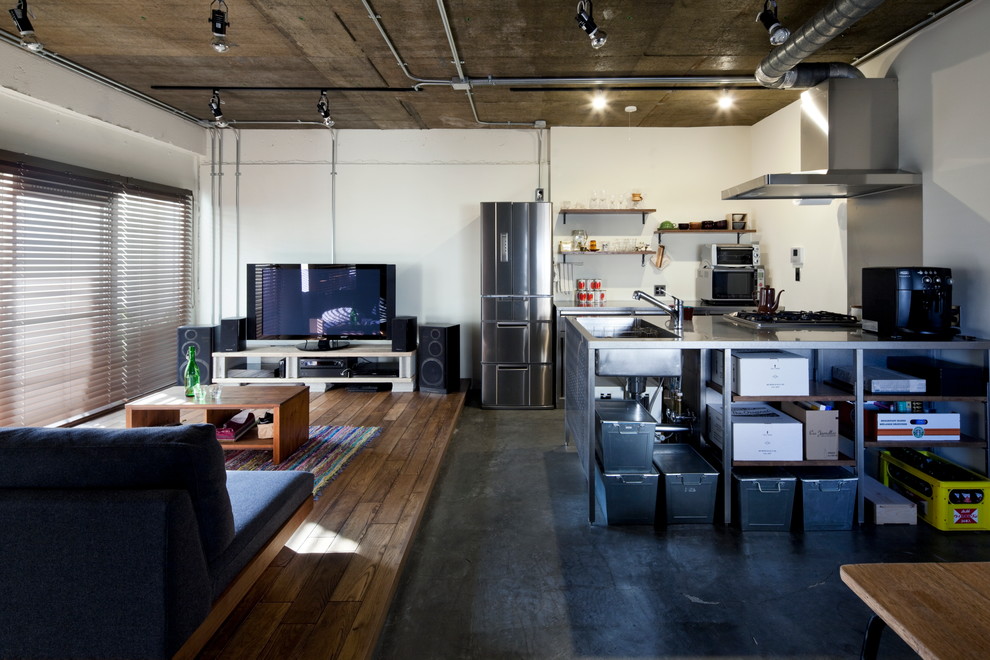 Bild på ett industriellt linjärt kök, med en integrerad diskho, öppna hyllor, skåp i mellenmörkt trä, bänkskiva i rostfritt stål, rostfria vitvaror, betonggolv och en halv köksö