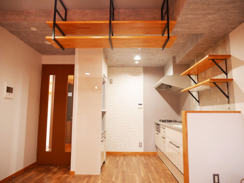 Inspiration för små 60 tals linjära kök med öppen planlösning, med en integrerad diskho, öppna hyllor, skåp i mellenmörkt trä, bänkskiva i koppar, grått stänkskydd, vinylgolv och brunt golv