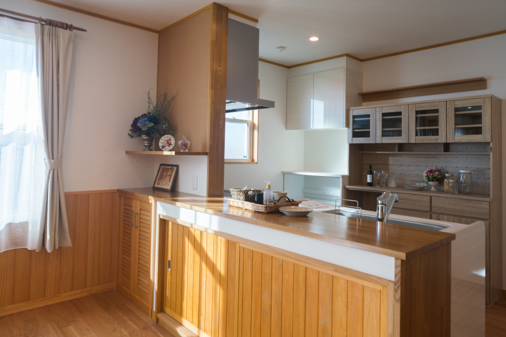 Idéer för att renovera ett mellanstort vintage vit linjärt vitt kök med öppen planlösning, med en undermonterad diskho, luckor med profilerade fronter, vita skåp, bänkskiva i koppar, vitt stänkskydd, glaspanel som stänkskydd, rostfria vitvaror, mellanmörkt trägolv, en köksö och brunt golv