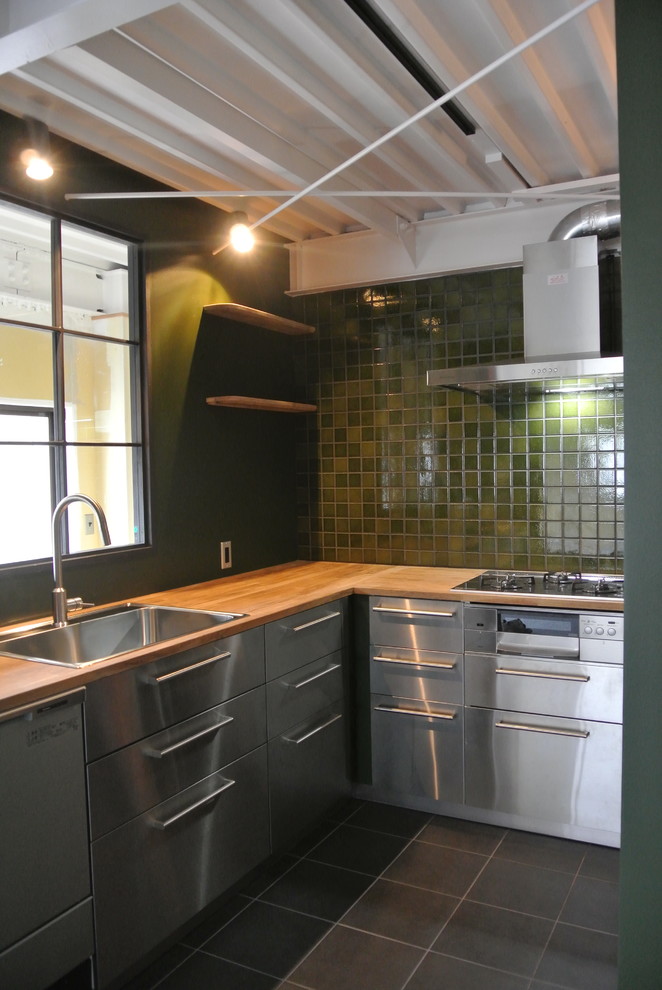 This is an example of an industrial l-shaped enclosed kitchen in Osaka with a built-in sink, flat-panel cabinets, stainless steel cabinets, wood worktops, green splashback, stainless steel appliances and no island.