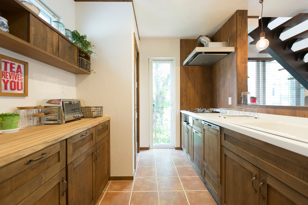 Idée de décoration pour une cuisine champêtre avec un placard avec porte à panneau encastré et des portes de placard marrons.