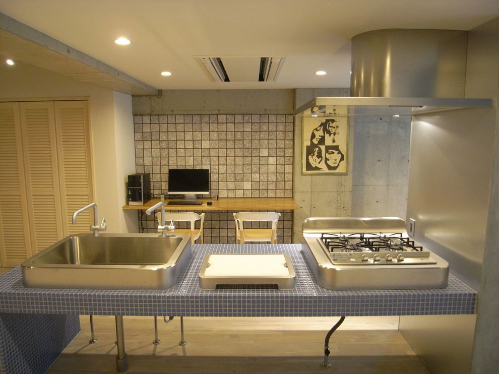 Exempel på ett mellanstort industriellt turkos turkost kök, med en nedsänkt diskho, turkosa skåp, kaklad bänkskiva, rostfria vitvaror, ljust trägolv, en halv köksö och beiget golv