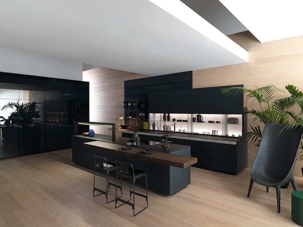На фото: параллельная кухня в стиле модернизм с одинарной мойкой, плоскими фасадами, черными фасадами, деревянным полом, островом и бежевым полом