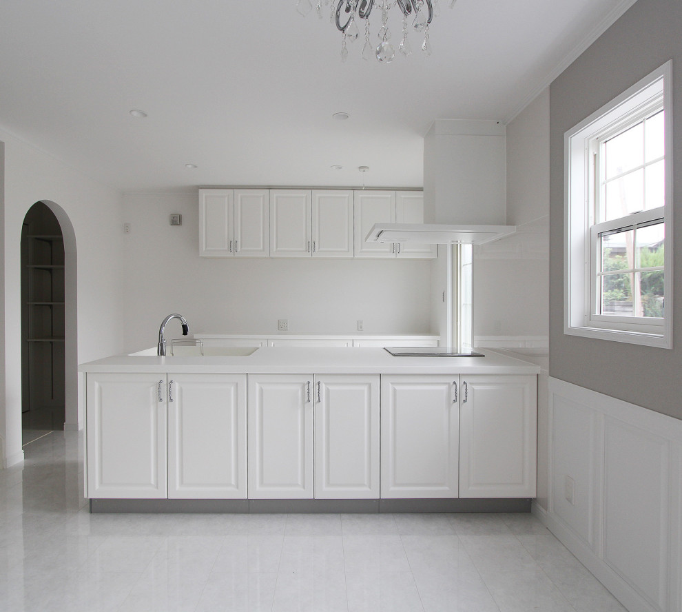 Diseño de cocina minimalista abierta con fregadero integrado, puertas de armario blancas, encimera de acrílico y encimeras blancas