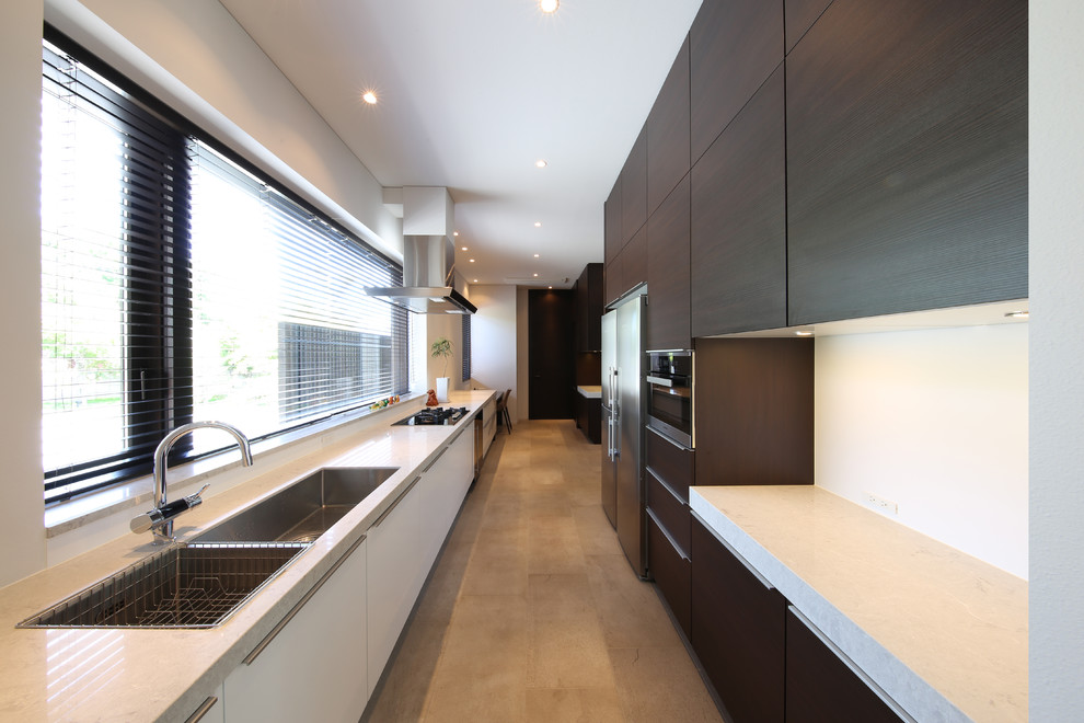 Ejemplo de cocina lineal contemporánea cerrada con fregadero de doble seno, armarios con paneles lisos, puertas de armario de madera en tonos medios y suelo beige