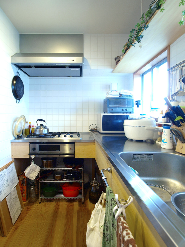 Idéer för avskilda skandinaviska l-kök, med en integrerad diskho, öppna hyllor, bänkskiva i rostfritt stål och beiget golv