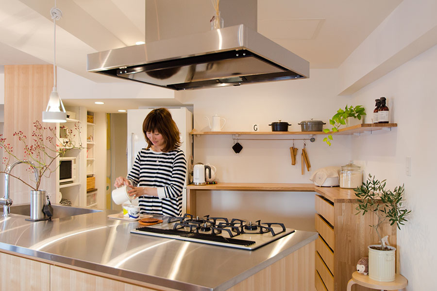 札幌にある中くらいな北欧スタイルのおしゃれなキッチン (一体型シンク、フラットパネル扉のキャビネット、中間色木目調キャビネット、ステンレスカウンター、白い調理設備、セラミックタイルの床) の写真