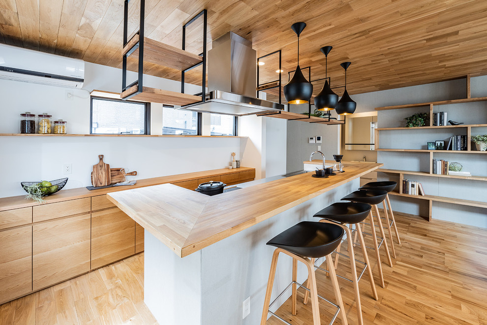 福岡にある北欧スタイルのおしゃれなアイランドキッチン (フラットパネル扉のキャビネット、淡色木目調キャビネット、木材カウンター、淡色無垢フローリング) の写真