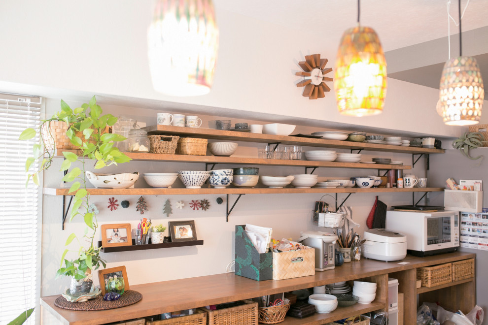 Modelo de cocina comedor lineal de estilo zen con fregadero integrado, armarios con paneles lisos, salpicadero blanco, suelo de madera oscura, una isla y papel pintado