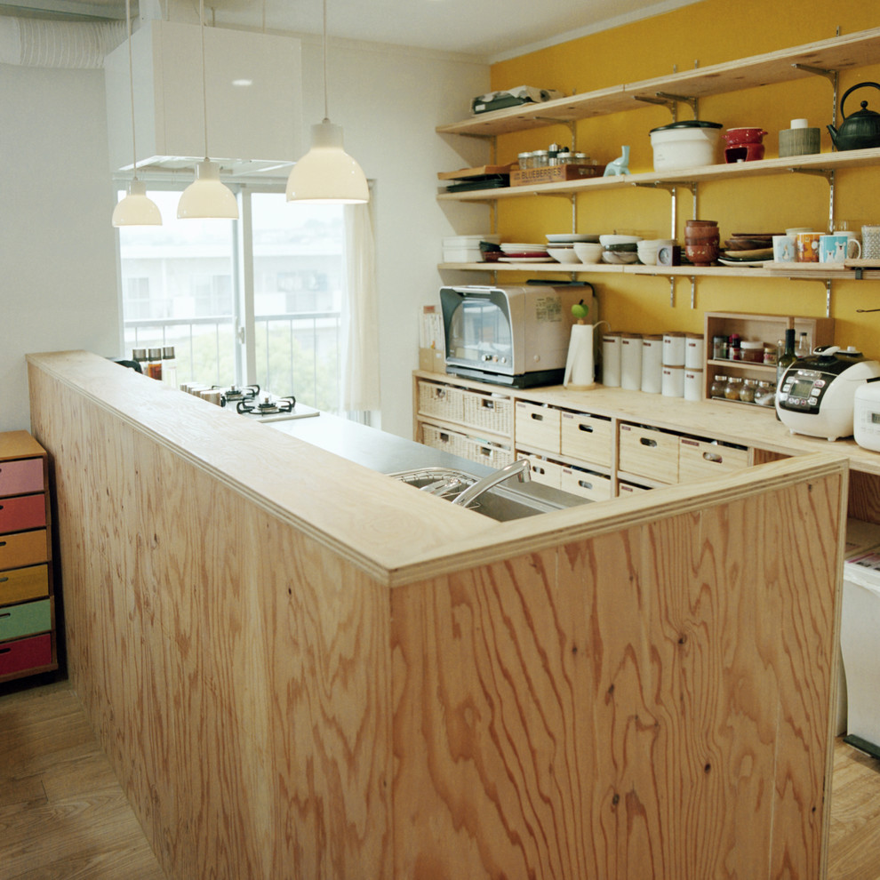 Moderne Küche in L-Form mit offenen Schränken, integriertem Waschbecken, braunen Schränken, Arbeitsplatte aus Holz, Küchenrückwand in Beige, braunem Holzboden und Kücheninsel in Yokohama