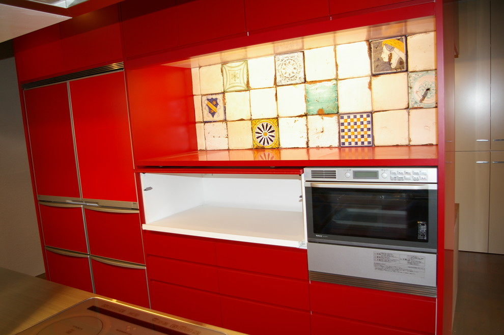 Idéer för mellanstora funkis linjära kök och matrum, med en undermonterad diskho, släta luckor, röda skåp, bänkskiva i rostfritt stål, flerfärgad stänkskydd, stänkskydd i porslinskakel, integrerade vitvaror, mellanmörkt trägolv och en köksö