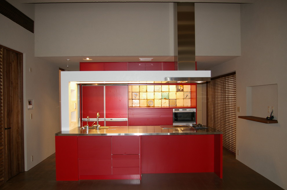 Exempel på ett mellanstort modernt linjärt kök och matrum, med en undermonterad diskho, släta luckor, röda skåp, bänkskiva i rostfritt stål, flerfärgad stänkskydd, stänkskydd i porslinskakel, integrerade vitvaror, mellanmörkt trägolv och en köksö