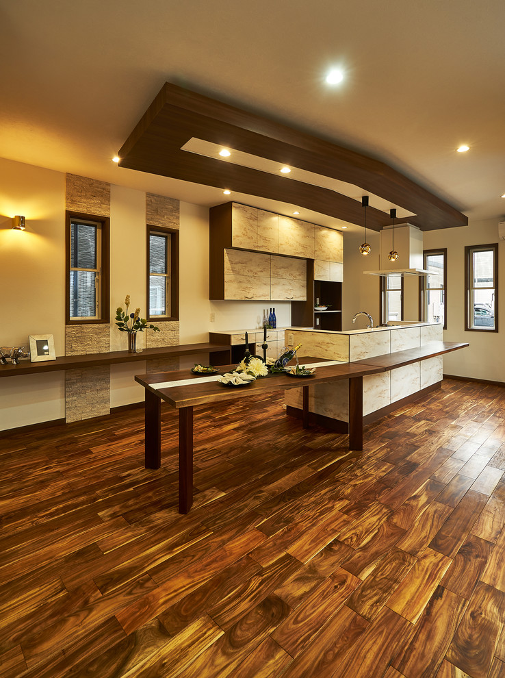 Foto di un cucina con isola centrale etnico con ante lisce, pavimento in legno massello medio e pavimento marrone