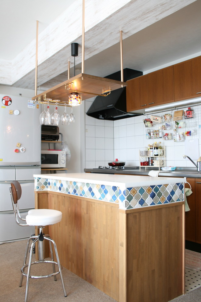 他の地域にあるエクレクティックスタイルのおしゃれなキッチン (シングルシンク、白いキッチンパネル、白いキッチンカウンター、フラットパネル扉のキャビネット、中間色木目調キャビネット) の写真