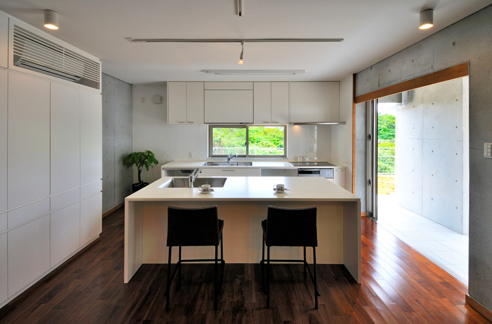 Esempio di una cucina industriale con lavello a vasca singola, ante lisce, ante bianche, parquet scuro e pavimento marrone