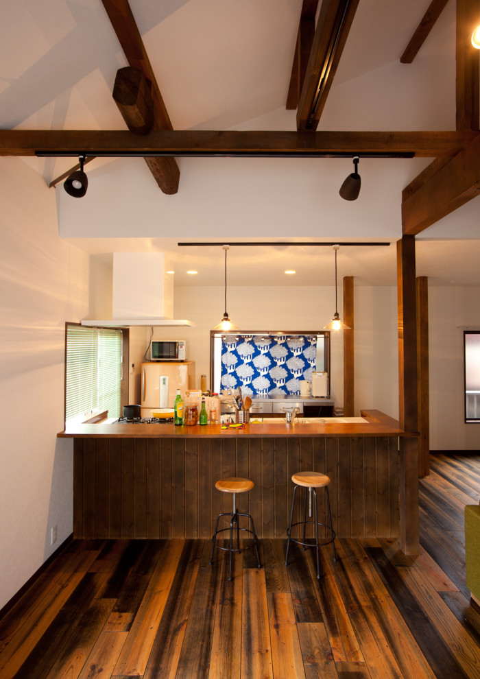 Свежая идея для дизайна: параллельная кухня-гостиная в восточном стиле с одинарной мойкой, цветной техникой, темным паркетным полом, островом и коричневым полом - отличное фото интерьера