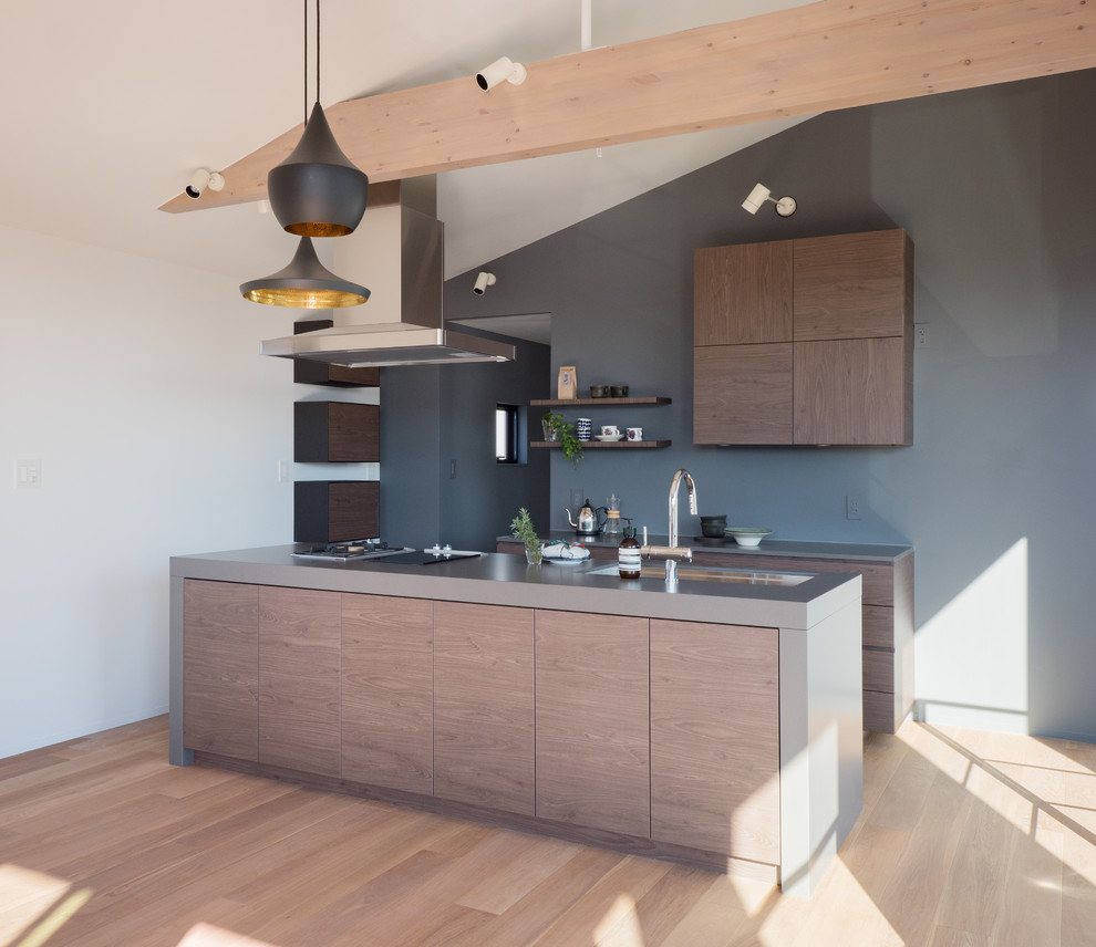 Esempio di una cucina minimalista con lavello a vasca singola, ante lisce, ante in legno scuro, top in acciaio inossidabile, pavimento in legno verniciato e pavimento beige