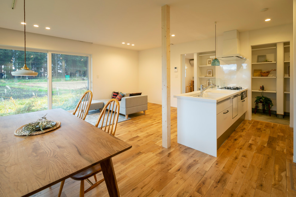 Idéer för ett litet minimalistiskt vit linjärt kök med öppen planlösning, med en integrerad diskho, luckor med profilerade fronter, vita skåp, bänkskiva i koppar, vitt stänkskydd, mellanmörkt trägolv, en köksö och beiget golv