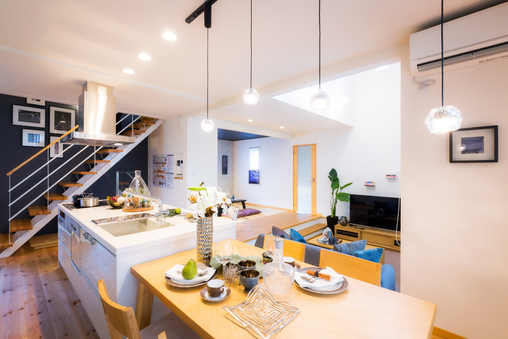 Immagine di una cucina ad ambiente unico minimal con pavimento in legno massello medio e pavimento marrone