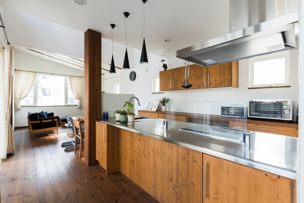 Idéer för att renovera ett orientaliskt kök, med en enkel diskho, skåp i mellenmörkt trä, bänkskiva i rostfritt stål, mellanmörkt trägolv och brunt golv