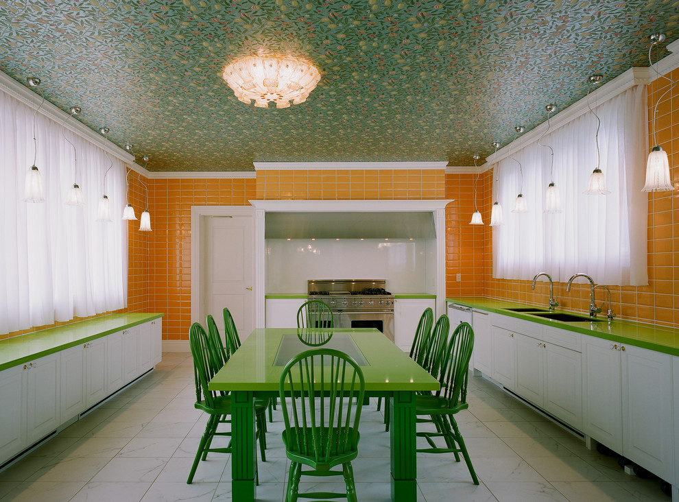 Пример оригинального дизайна: угловая кухня в викторианском стиле с обеденным столом, двойной мойкой, фасадами с выступающей филенкой, белыми фасадами, оранжевым фартуком, фартуком из плитки кабанчик и техникой из нержавеющей стали