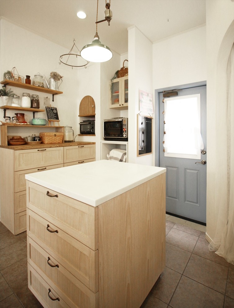 Immagine di un cucina con isola centrale etnico con ante lisce, ante beige, paraspruzzi beige e elettrodomestici da incasso